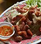 Sai mu thot, deep-fried pork intestines, here served with spicy nam chim (Thai dipping sauce)