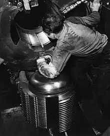 Welin breechblock of a 16-inch Mk 6 gun on USS Alabama (BB-60), 1943. Note the four separate thread "steps" on the block which engage with matching steps in the breech when the block is swung up and inwards and then rotated slightly clockwise. The design allows thread to be machined on four-fifths of the circumference but requires only a one-fifth turn to disengage. A conventional interrupted thread would have thread on only half of its circumference and would need to be much longer to achieve the same strength.