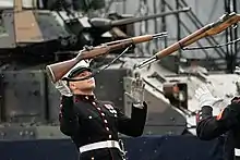  Two members of the United States Marine Corps Silent Drill Platoon get ready to catch their rifles which they have tossed up in the air.