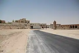 Sandy road near the beach with the historic Al Thakhira Mosque seen on the right.