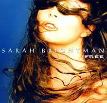 A portrait backed in the colour of blue of the front facial profile of a brunette woman. The woman has slightly curled hair which is blown to the left across her face. In the centre of the portrait in thin, white, capital font is her name 'Sarah Brightman' with the title 'Free' visible in a reduced font directly below it on its right corner.