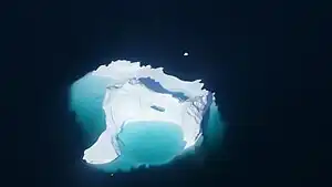 Aerial view of an iceberg floating in Sarqarput Strait