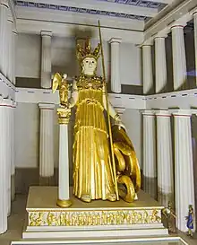 Statue en marbre d'une femme casquée avec une lance et un bouclier ; elle tient une figure ailée dans la main droite