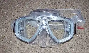 A diving half mask provides clear sight and protection for the eyes.