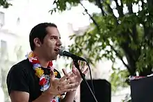 Man in Hawaiian shirt talking into a microphone