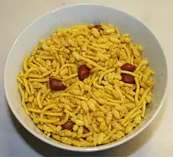 A bowl of sev mamra, consisting of puffed rice, peanuts and fried seasoned noodles