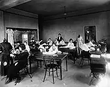 Young women at sewing machines and tables