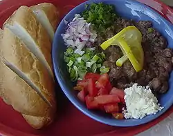 fulBeans with variety of vegetables, feta cheese and bread, flavored with Berbere spice and olive oil.