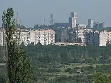 Mine in the distance, behind apartment buildings and green space