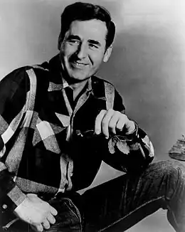 A dark-haired man wearing a check shirt