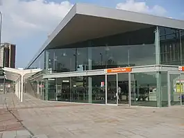 metal and glass building with swing doors and stairs on Shepherd's Bush Green