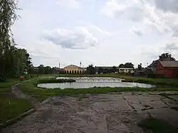 Pond in village, church in background