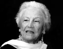 Black and white portrait of Silvana Lattmann. Head and shoulders of distinguished older woman with scarf draped elegantly over neck. She has short light-coloured hair and is wearing dangling earrings.