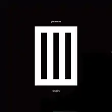 A white rectangle in the middle of a black background. The rectangle contains three black, vertical bars. "paramore" is written in white text above the rectangle and "singles" underneath it.
