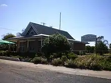 One-story medical building with pitched roof, surrounded by shrubbery