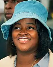 head shot of young woman wearing denim blue wide brimmed hat