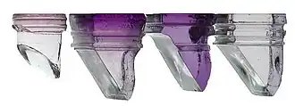 Shallow purple glass squares with deep right-angled prisms hanging from them. They are coloured purple, with the shade intensifying towards the top.