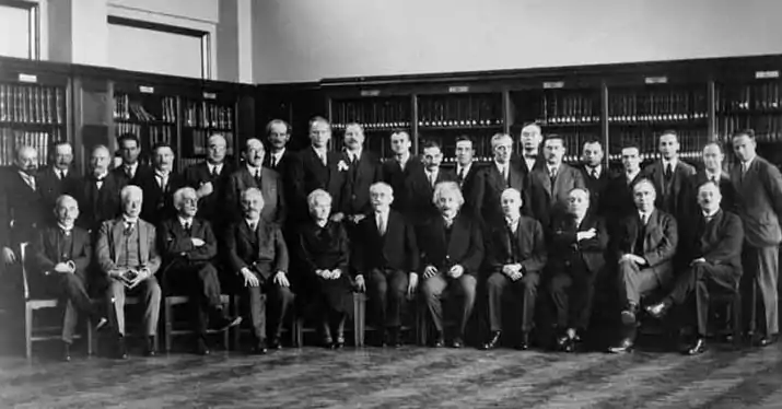 Sixth Conference, 1930. 1st row: Th. de Donder, P. Zeeman, P. Weiss, A. Sommerfeld, M. Curie, P. Langevin, A. Einstein, O. Richardson, B. Cabrera, N. Bohr, W. J. De Haas; 2nd row: E. Herzen, E. Henriot, J. Verschaffelt, C. Manneback, A. Cotton, J. Errera, O. Stern, A. Piccard, W. Gerlach, C. Darwin, P. A. M. Dirac, H. Bauer, P. Kapitsa, L. Brillouin, H. A. Kramers, P. Debye, W. Pauli, J. Dorfman (ru), J. H. Van Vleck, E. Fermi, W. Heisenberg