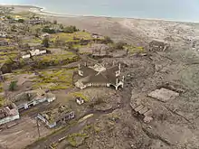 Partially buried buildings near the shore.