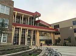 Front entrance of the school, featuring a three-story glass facade between two brick structures