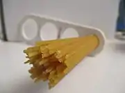 Dried spaghetti measured with a "spaghetti measure". One portion of dried pasta weighs 116 g (4+1⁄8 oz), twice the amount of one serving on the package (12 mm circle or 60 g.). The measure can portion out 1, 2, 3, or 4 servings based on the diameter of the circle.