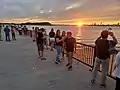Visitors on the ferry pier at sunset