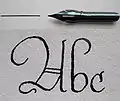 A steel nib with a sample of writing (A b c: the ascender of the "b" is an example of a pothook)