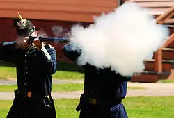 Reenactor firing a Springfield Model 1873 breech-loading rifle at Fort Mackinac in 2008