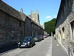 Street of grey stone houses. The church tower can be seen n the background
