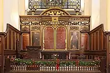 Church altar with four wooden panels, two of which show Moses and Aaron