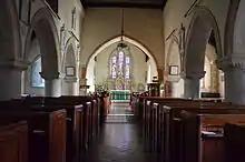 The interior of St Mary's Church, showing the stained glass windows and various plaques on the walls