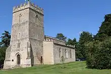 A three-storey, castellated, tower to the left, with a wide nave and aisles. All in white limestone