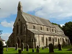 19th century stone church with side aisles and bell gable