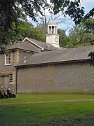 The stable block at Sheringham Hall with its cupola bell turret faced with a clock.