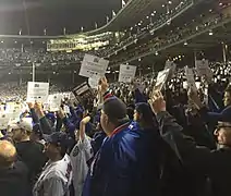 Fans participate by rising and holding signs at game 4 of the 2016 World Series