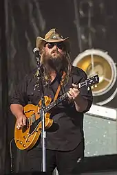 A picture of country music singer Chris Stapleton playing an electric guitar.