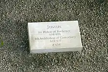 Stone set on the ground inscribed with "Justus, first Bishop of Rochester 604–624, fourth Archbishop of Canterbury 624–627, d. 627"