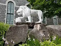 Cement lion on the north-east side of the church of Sainte-Thècle fashioned by the priest Maxime Masson.