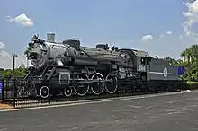 An old steam locomotive on static display with faded paint