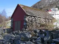 Stone-walled Norwegian boathouse set into a hillside