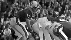 Quarterback, crouched and waiting for the ball