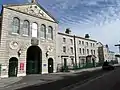 Part of the west front (1867–71) including main entrance and former houses for senior officers, now offices.