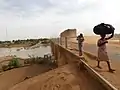 Two young pedestrians cross the road bridge from Mali to Kidira, Senegal. Left the ford in the river Falémé, 2017.