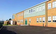 A picture taken outside depicting the rear of the school's extension with a blue sky overhead