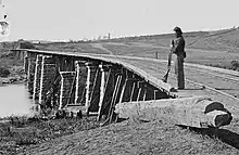 Black and white photo shows the railroad span across the Holston River at Strawberry Plains, with a Union sentry.