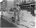 Street types of New York City-Street cleaner with pick ax standing in front of pile of snow
