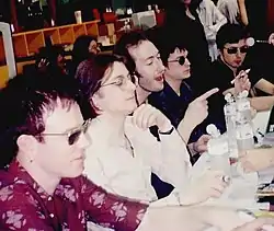 Five men sitting at a table at a press conference