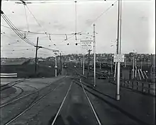 A junction between two streetcar lines, with a rail yard in the background