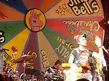 Stevens performing in front of a large song wheel