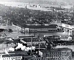 A black and white photograph of a baseball stadium located in a flooded city.